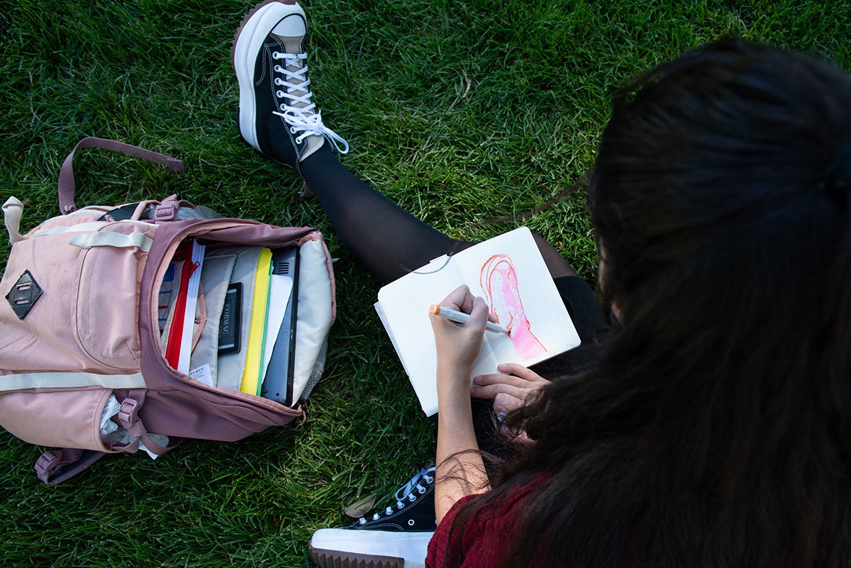Saya Zeleznik draws her foot in her sketchbook at the center of Presidents Circle at the University of Utah campus in Salt Lake City on Tuesday, September 26, 2023.