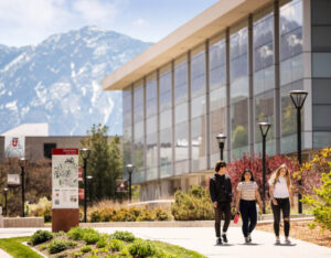 some students taking a walk through campus, with the library in the background