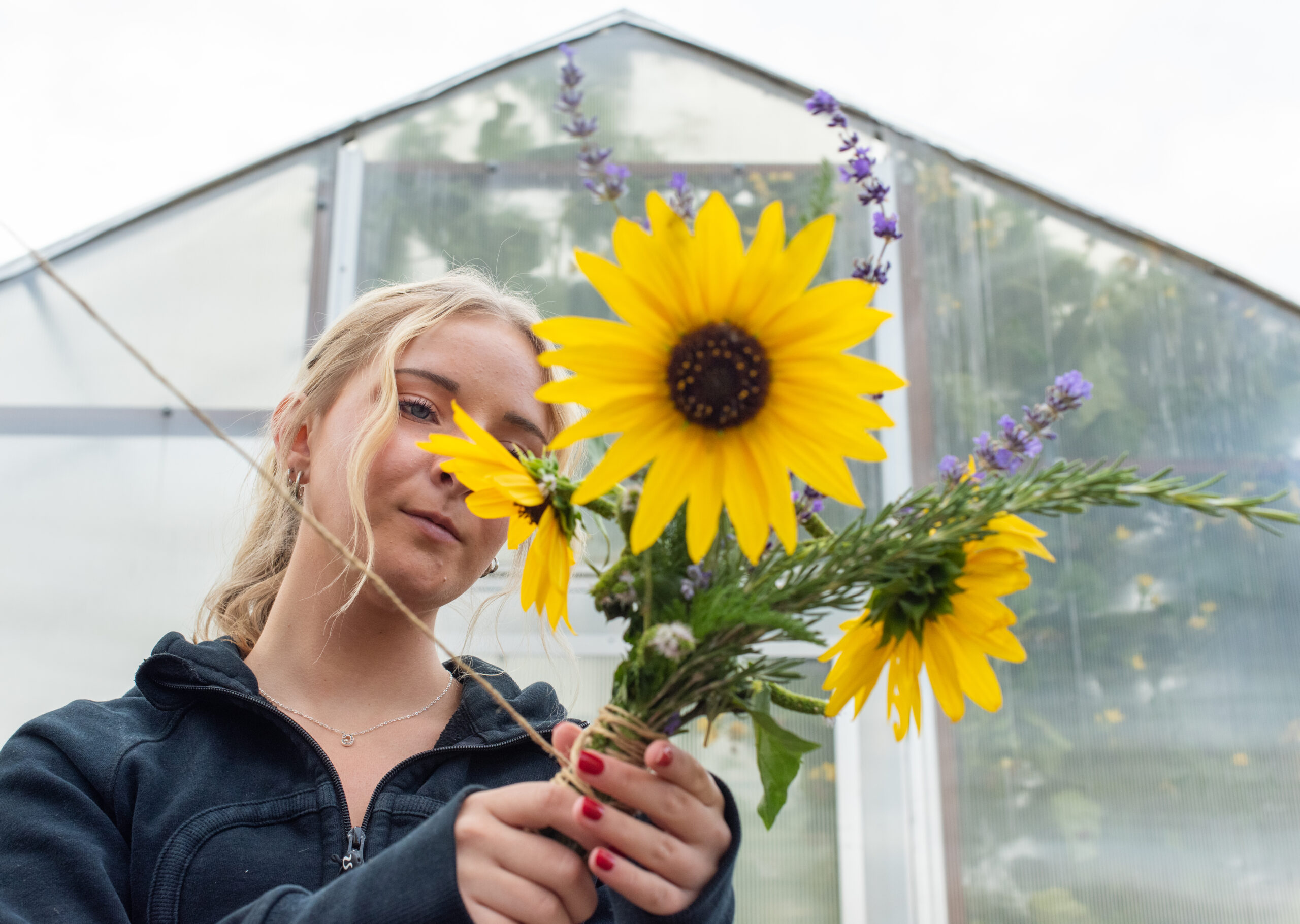 Student makes a bouquet during the end of the year garden event at the Nuh Eevaat Garden