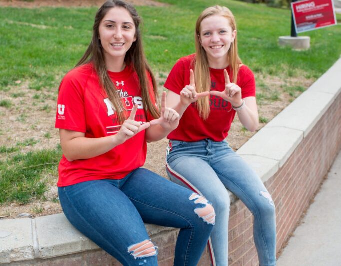 Trish-Griffee-Photography-5656-scaled-e1683224100635-682×532 a couple of students doing the U hand sign