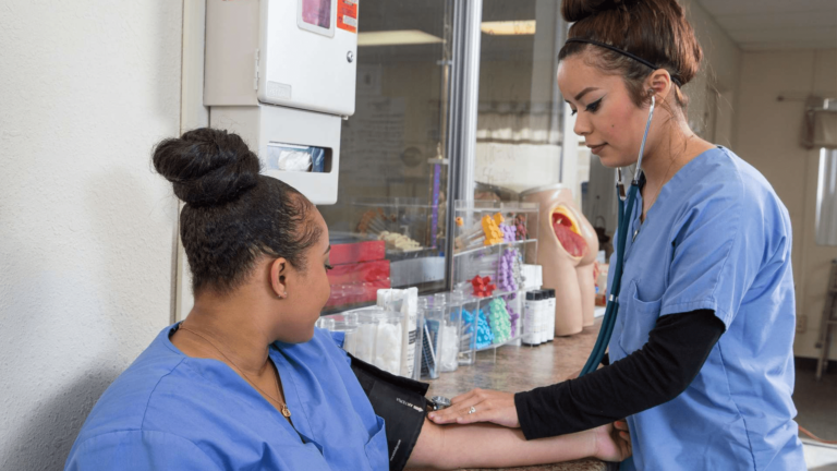 a couple of nursing students practicing reading vital signs
