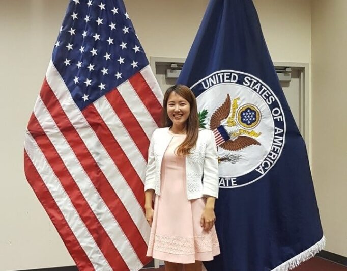 JenniferShinUSFSO-682×532 a student in front of the flag of the USA and a federal flag