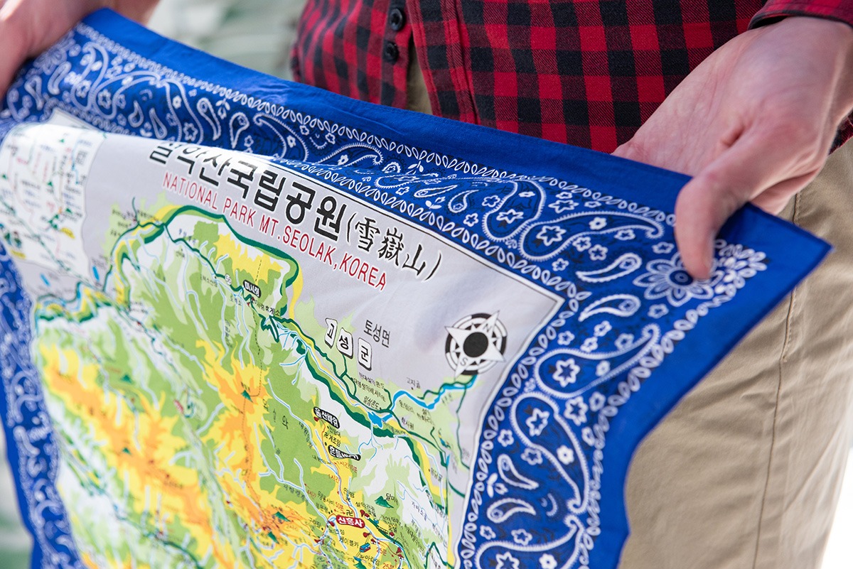 Derek shows an ornately designed cloth with a map of a part of Korea on it
