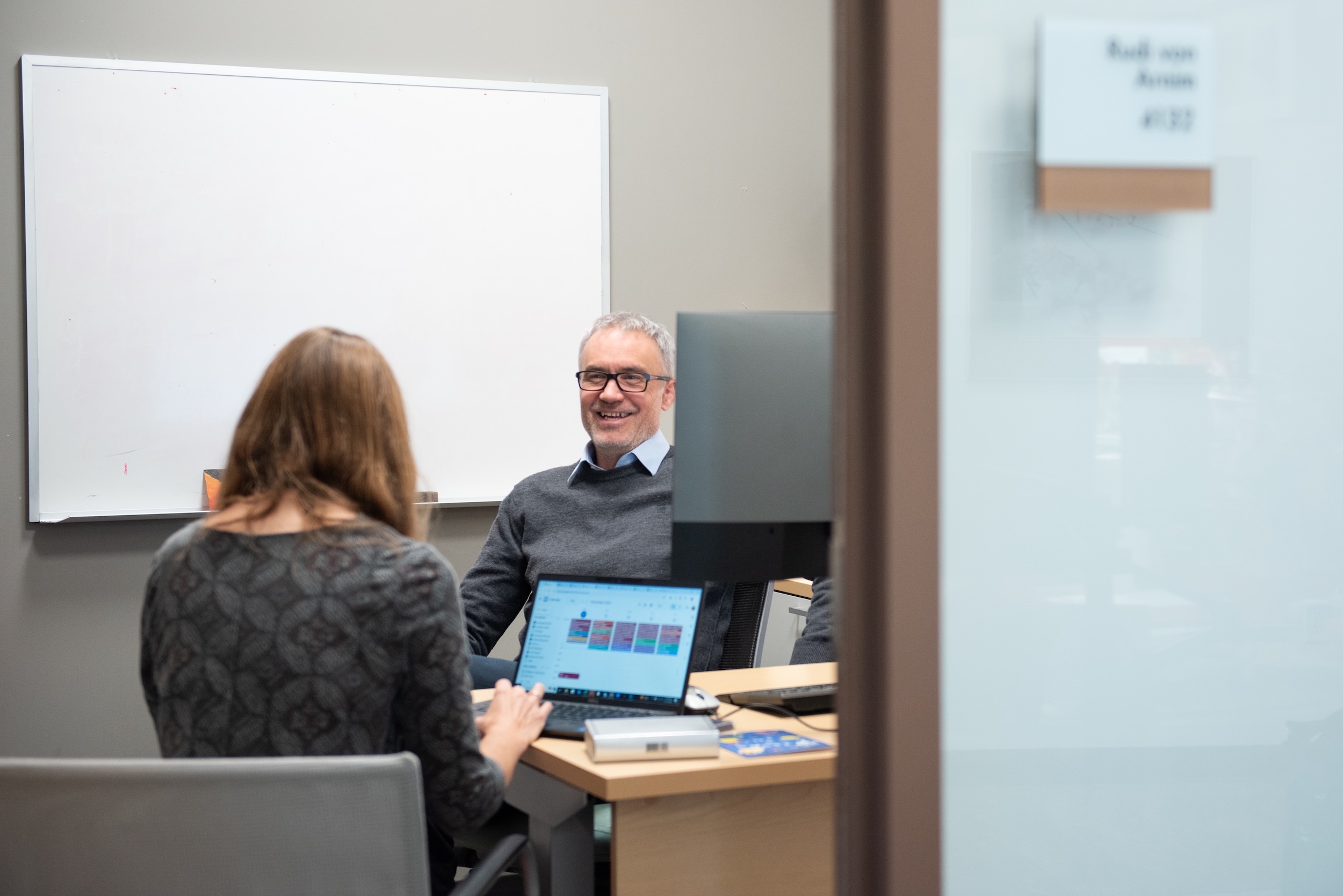 a student and a professor working together in the professor's office